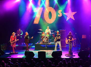A picture of the band 'Let's Rock 70s' performing on a stage.