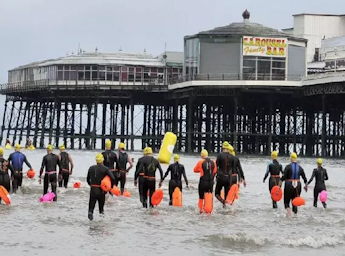 A picture of people in wet suits next to the north pier.
