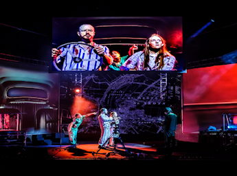 A picture of 3 people in  a car and a cameraman. 