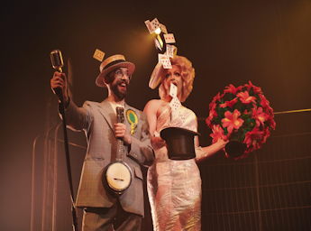 A picture of a man magiican and his assistant on stage.