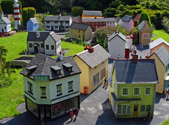 Picture of grass with 16 model houses representing a village.