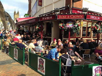 Picture of the front of the Rose & Crown pub with its large outdoor seating area.
