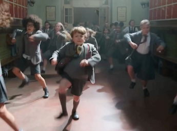 A picture of school children in uniform dancing.