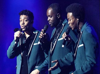 A picture of 3 singers performing.