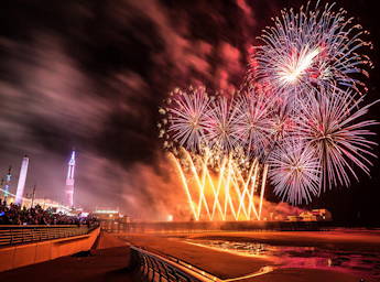 Fireworks from the North Pier with people watching from the promenade.