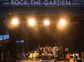 Band on stage wit Queens crest on red background.