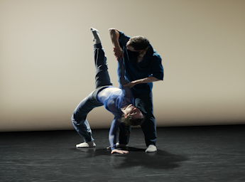 A picture of two dancers performing an acrobatic move.